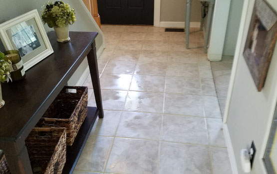 A hallway with a newly renovated tile floor and a wooden table